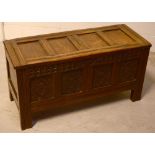 An 18th century panelled oak coffer with later carving, height 51cm, width 99cm.