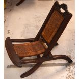 An early-to-mid 20th century African hardwood folding nursing chair with chip carved decoration to