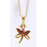 A 9ct yellow gold butterfly pendant with red stone detail suspended on a 38cm yellow metal curb
