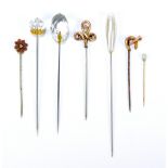 Seven various hat and tie pins including a horseshoe and hunting horn decorated example,