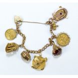 A 9ct yellow gold curb link charm bracelet with heart clasp and eight charms/pendants,