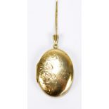 A 9ct yellow gold oval locket pendant engraved with foliate scrolls, 4 x 2.
