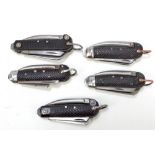 Five military checkered black bodied clasp knives, each with hinged spike,