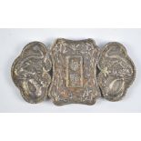 A Chinese silver three sectioned buckle decorated with dragons and character marks to the central
