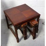 A reproduction nest of three tables comprising a large square table on reeded supports and two