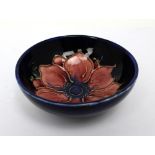 Moorcroft; a cobalt blue ground small bowl with pink clematis decoration, diameter 9cm,