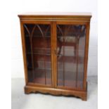A reproduction mahogany twin glazed door display cabinet with three interior glass shelves,