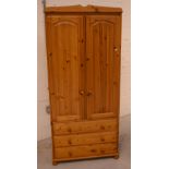 A modern pine wardrobe of two doors over three long drawers, height 180cm, width 83cm.