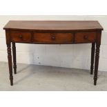 A 19th century mahogany bow-fronted writing table with three frieze drawers on turned supports,