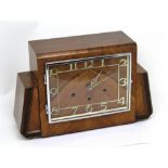 An early 20th century walnut-veneered Art Deco mantel clock, the dial set with Roman numerals.