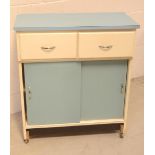 A vintage kitchen cabinet, two drawers over two sliding doors, in white and blue painted finish.