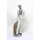 A Lladró figure of a sailor in uniform with duffel bag, height approx 34cm, boxed.