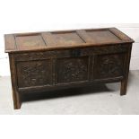 A late 18th century oak coffer, with three-panel hinged lid above a carved panel front, width 126cm.