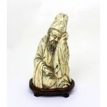 A well-carved 19th century Chinese carved ivory figure of a sleeping scholar/Li Bai with a book or