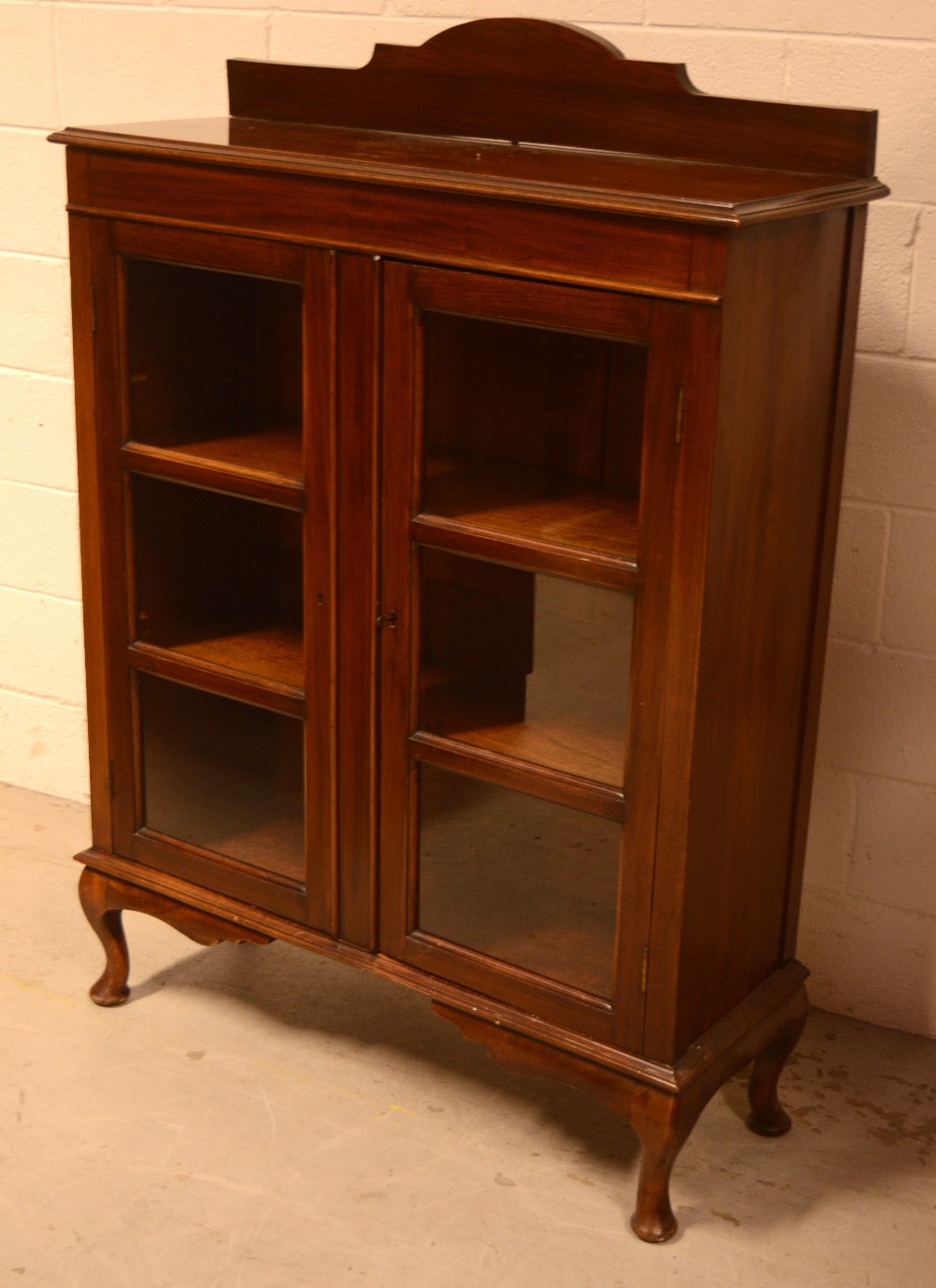 A c1920s mahogany two-door glazed bookcase on cabriole supports, 127 x 102cm.