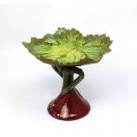 A Bretby green leaf-moulded dish on a red and green glazed stylised tree stand,