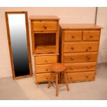 A pine two-over-four tall chest of drawers, three non-matching pine bedside cabinets,