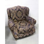 A contemporary wing-back armchair upholstered in midnight blue floral fabric on squat baluster