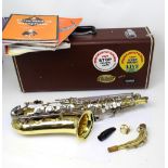 A cased Yamaha alto saxophone and a small quantity of saxophone related music books.