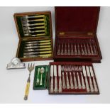 An oak-cased set of twelve knives and forks with silver collars,