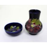 Moorcroft; a cobalt blue ground baluster vase with clematis pattern,