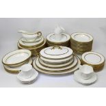 A quantity of Royal Doulton dinnerware with gilt decoration to include meat platters,