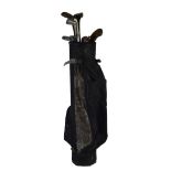 A quantity of early 20th century sporting equipment including golf clubs in a golf bag including