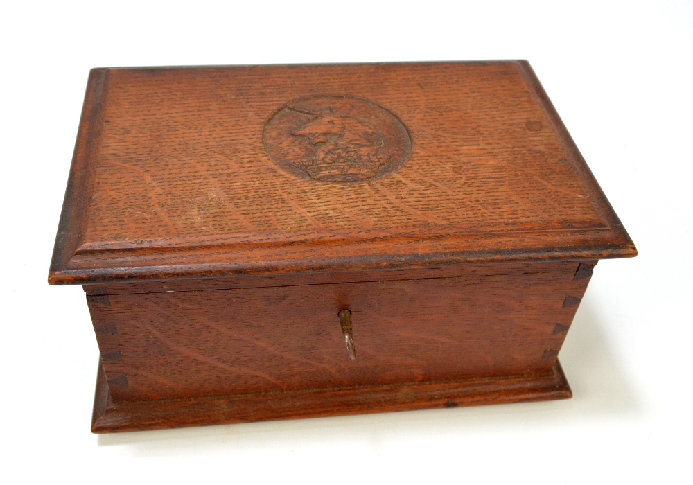 An oak trinket box with carved detail to the lid and inscribed 'This oak was part of