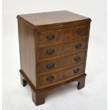 A small reproduction walnut chest of four drawers on bracket feet.