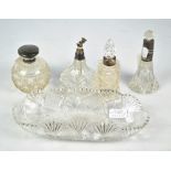 A silver topped cut glass perfume bottle, two silver mounted perfume bottles,