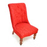 A Victorian mahogany framed red upholstered nursing chair, on turned front legs.