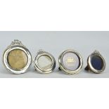 Three variously hallmarked silver circular photograph frames with ribbon decorated tops,