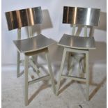 A pair of painted wooden and brushed aluminium bar stools.