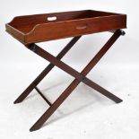 A 19th century mahogany butler's tray on folding stand with canvas straps, width 82cm, height 65cm.