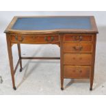 An Edwardian mahogany and inlaid single pedestal desk with inset leather to the shaped top,