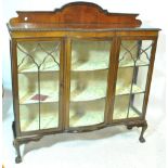An early 20th century mahogany display cabinet with two astragal glazed doors on four ball and claw