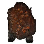 A decorative curved piece of tree trunk with inset lotus blossom and bulb decoration,