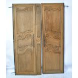 A pair of late 19th/early 20th century French oak armoire doors with carved foliate and scroll