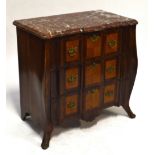 A 19th century Continental rosewood and satinwood veneered three drawer commode of serpentine