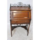 A late 19th/early 20th century mahogany bureau with wrought iron gallery,