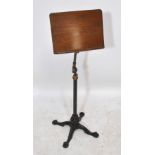 A Victorian mahogany adjustable reading/music stand on cast iron and brass base terminating in paw