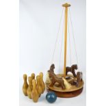 A carved wooden carousel toy, height approx 78cm, and a set of carved wooden skittles and ball.