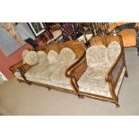 An Edwardian walnut Bergère three-piece suite comprising a three seater settee and a pair of