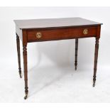 An early 19th century mahogany single drawer side table on turned supports to brass castors.