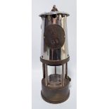 An early to mid-20th century miner's safety lamp stamped 'The Protector Lamp & Lighting Co Ltd Type