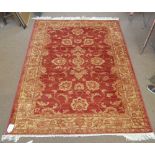 A red ground Ziegler carpet with foliate scrolls in beige and orange ground within ornamental