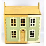 A green painted two storey doll's house with attic and four internal rooms, width 63.5cm.