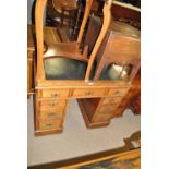 A Victorian walnut kneehole pedestal desk with gilt tooled green leather writing surface,