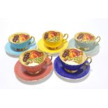 A set of five variously coloured glazed Aynsley tea cups and saucers transfer decorated with grapes,