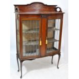 An Edwardian mahogany and inlaid serpentine fronted display cabinet,